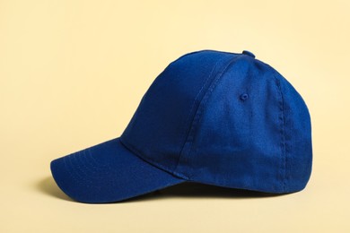 Stylish blue baseball cap on beige background