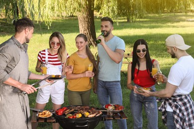 Group of friends having barbecue party in park