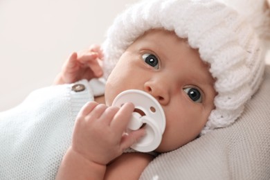 Photo of Adorable newborn baby with pacifier on white background, closeup