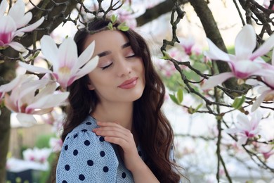 Photo of Beautiful woman near blossoming magnolia tree on spring day