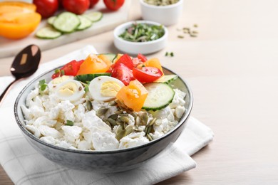 Fresh cottage cheese with vegetables, seeds and eggs in bowl on wooden table
