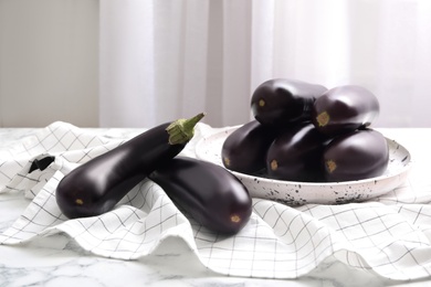 Raw ripe eggplants on white marble table