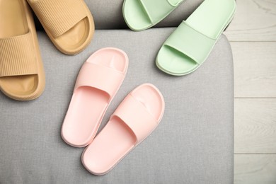 Pairs of stylish rubber slippers indoors, top view