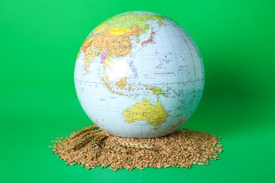 Globe with wheat grains on green background. Hunger crisis concept