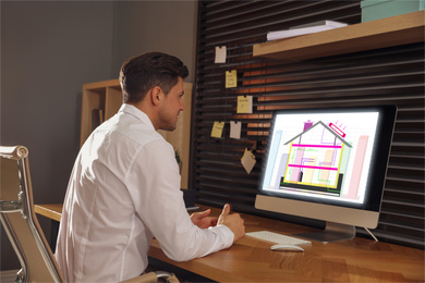 Image of Engineer at work. Man projecting house in office