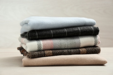 Photo of Stack of cashmere clothes on wooden table