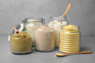 Jars with different types of flour on table
