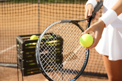 Sportswoman preparing to serve tennis ball at court, closeup