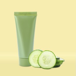 Makeup remover and fresh cucumber on yellow background