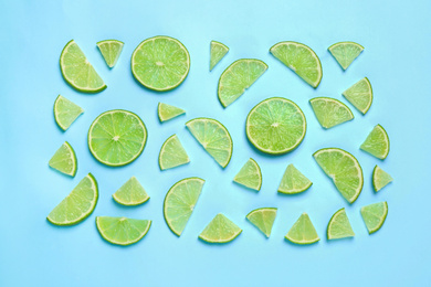 Juicy fresh lime slices on light blue background, flat lay