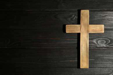 Christian cross on wooden background, top view with space for text. Religion concept