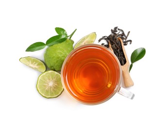Photo of Glass cup of tasty bergamot tea, dry leaves and fresh fruits on white background, top view