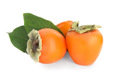 Delicious persimmons and green leaves isolated on white