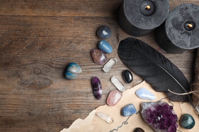 Flat lay composition with different gemstones on wooden background. Space for text