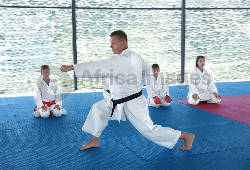 CHERNOMORKA, UKRAINE - JULY 10, 2020: Karate instructor with little children on training ground