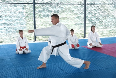CHERNOMORKA, UKRAINE - JULY 10, 2020: Karate instructor with little children on training ground