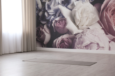 Grey yoga mat on floor in spacious room