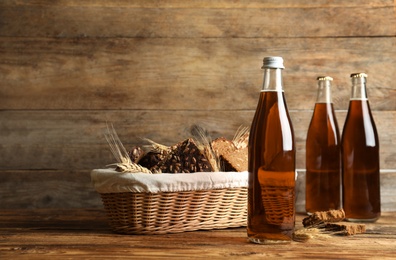 Bottles of delicious fresh kvass, spikelets and bread on wooden table