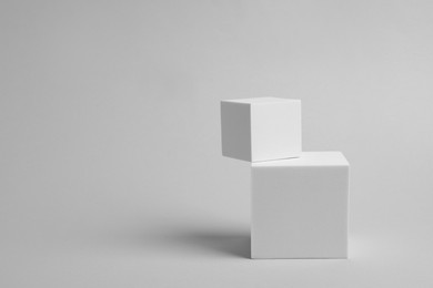 Scene with podium for product presentation. Cubes on light grey background, space for text