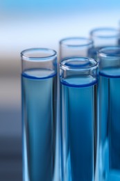 Test tubes with reagents on blurred background, closeup. Laboratory analysis