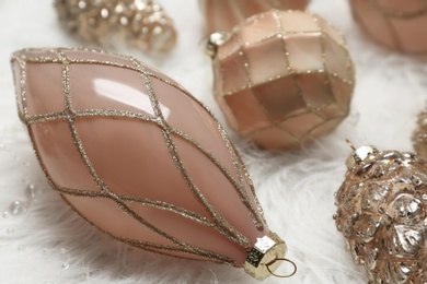 Collection of beautiful Christmas tree baubles on white faux fur, closeup