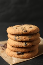 Photo of Delicious chocolate chip cookies on black table