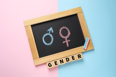 Word Gender and chalkboard with symbols on color background, top view