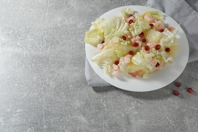 Photo of Delicious salad with Chinese cabbage, shrimps and pineapple served on grey table, space for text