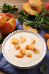 Delicious yogurt with fresh peach on table