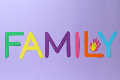 Photo of Happy Family Day. Card with word and paper hands cutouts on violet background, flat lay