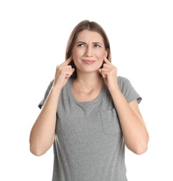Emotional young woman covering her ears with fingers on white background