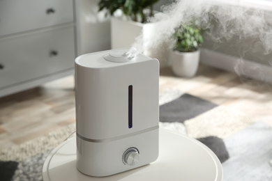 Modern air humidifier on table at home