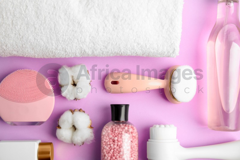 Photo of Flat lay composition with face cleansing brushes on violet background. Cosmetic tools