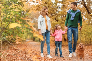 Photo of Happy family with child and dog in park. Autumn walk