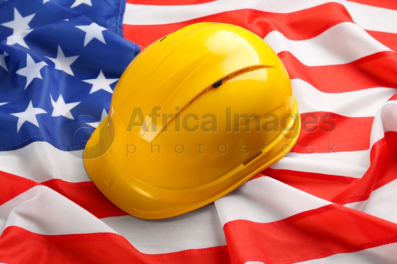 Yellow protective hard hat on American flag, closeup