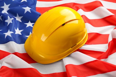 Yellow protective hard hat on American flag, closeup