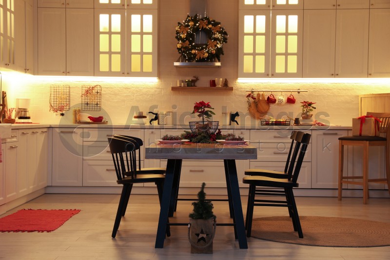 Cozy dining room interior with beautiful Christmas wreath and festive decor
