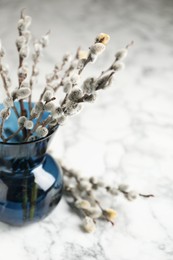 Beautiful pussy willow branches on white marble table, closeup