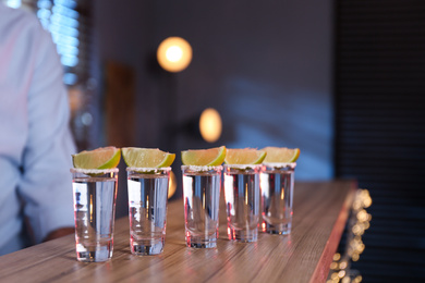 Mexican Tequila shots with salt and lime slices on bar counter