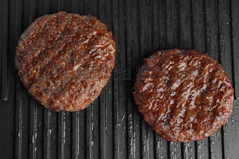 Prepared meat cutlets for burger on grill, top view