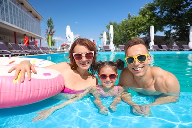 Happy family in swimming pool at resort
