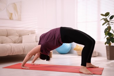 Photo of Overweight woman doing exercise on yoga mat at home