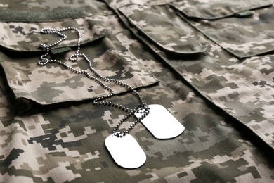 Military ID tags with chain on camouflage uniform