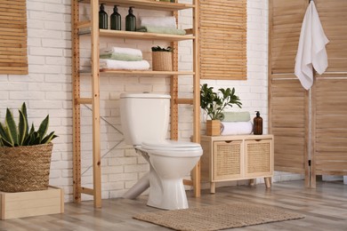 Stylish bathroom interior with toilet bowl and other essentials