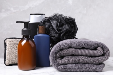 Photo of Cosmetic products and towel on white marble table. Men's hygiene