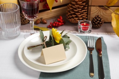 Beautiful autumn place setting with blank card and decor on table