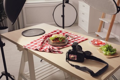 Professional camera and composition with tasty sandwich on table in photo studio. Food photography