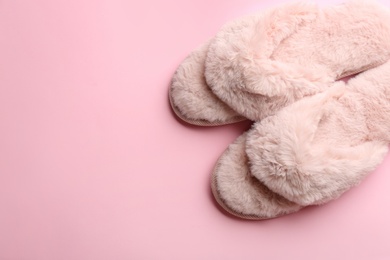 Pair of stylish soft slippers on pink background, flat lay. Space for text