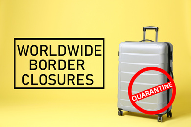 Worldwide border closures through quarantine during coronavirus outbreak. Suitcase and prohibition sign on yellow background