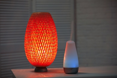 Photo of Modern essential oil diffuser on table indoors